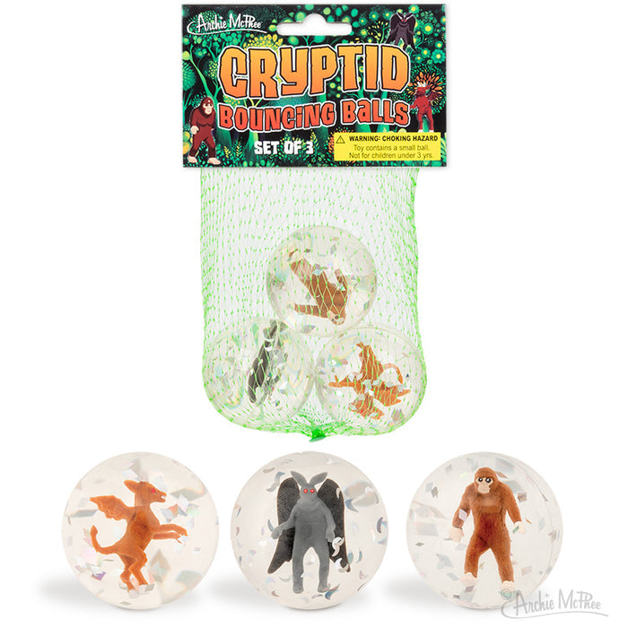 Three clear Cryptid Bouncing Balls, each containing a small cryptid or decapod figure, packaged in green mesh and labeled as Cryptid Bouncing Balls.
