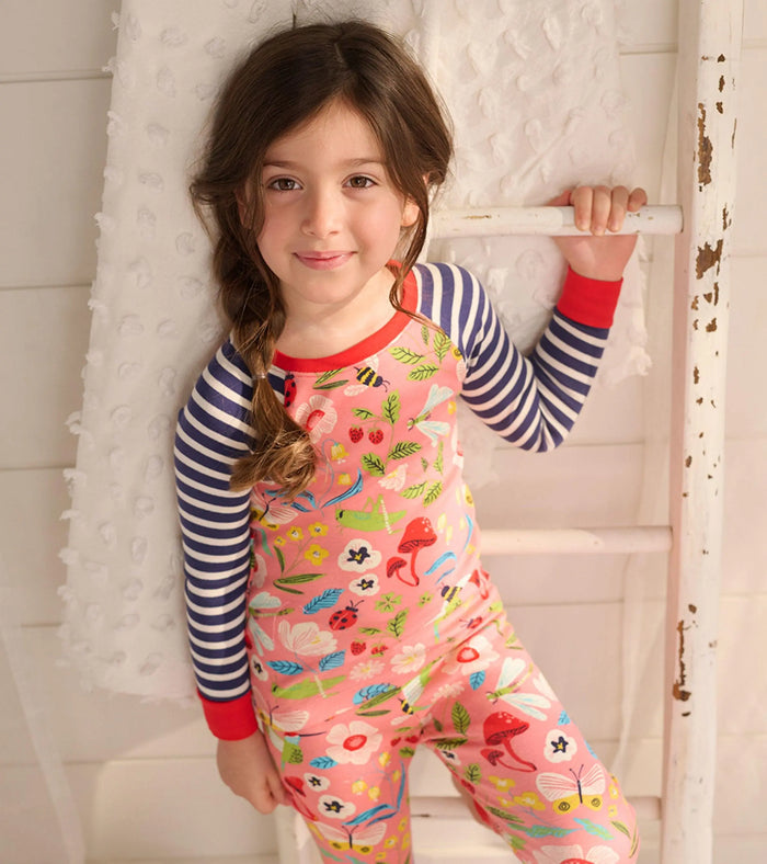 Hatley girls organic cotton pajama set with coral garden print, red cuffs, and navy striped sleeves.