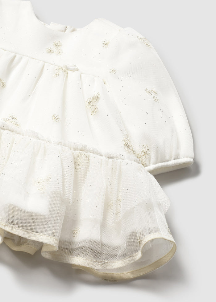 Closeup of gold dot tulle overlay and smooth lining at the neckline.