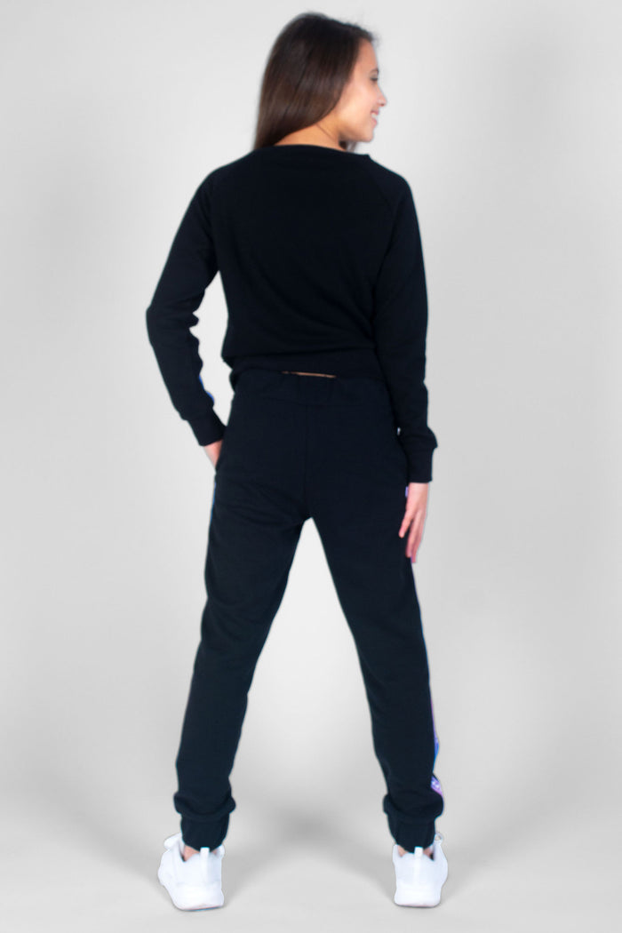 Girl wearing black TNS Tape Sweat Top and matching black joggers
