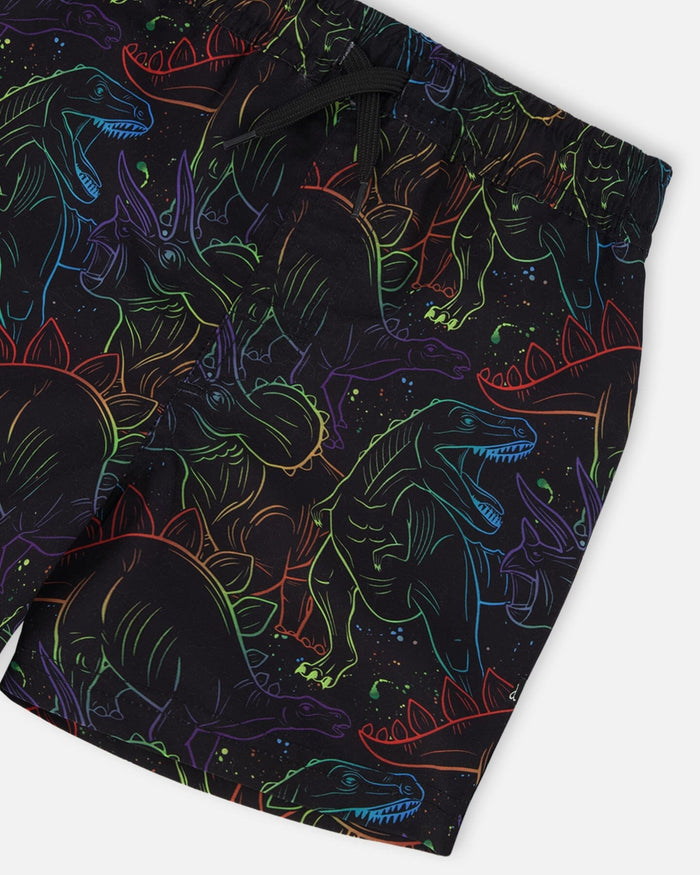 Close-up of waistband, drawstring, and neon dinosaur pattern on black swim shorts