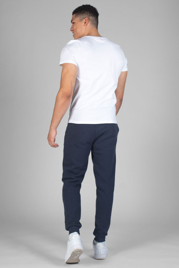 Man wearing white Unisex T-Shirt and charcoal jogging trousers with elastic cuffs