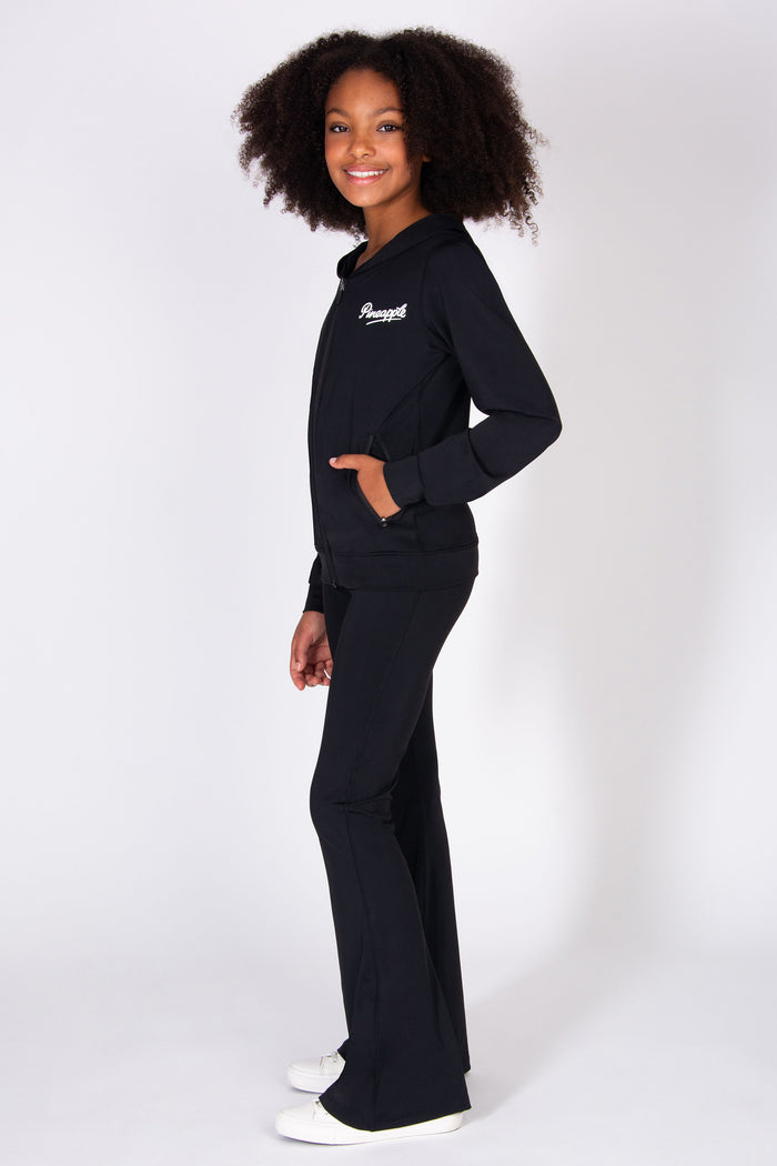 Girl wearing a black outfit with a logo on a white background