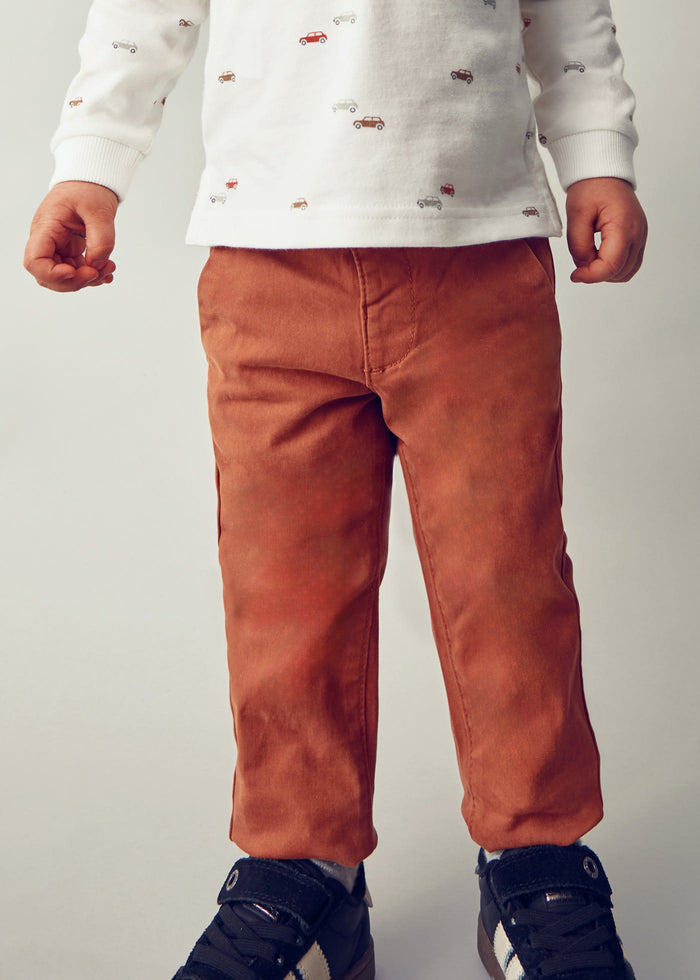 Closeup lifestyle view of Mayoral baby boy chinos showing waistband and slim-fit front.