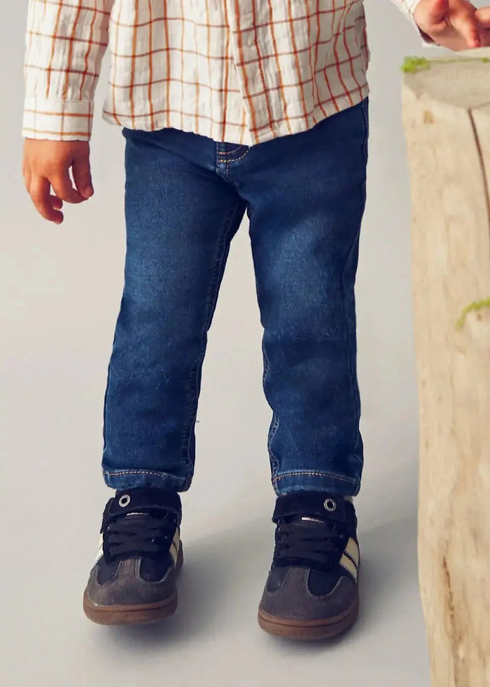 Closeup lifestyle view of Mayoral baby boy slim fit jeans showing dark denim wash and comfortable fit.