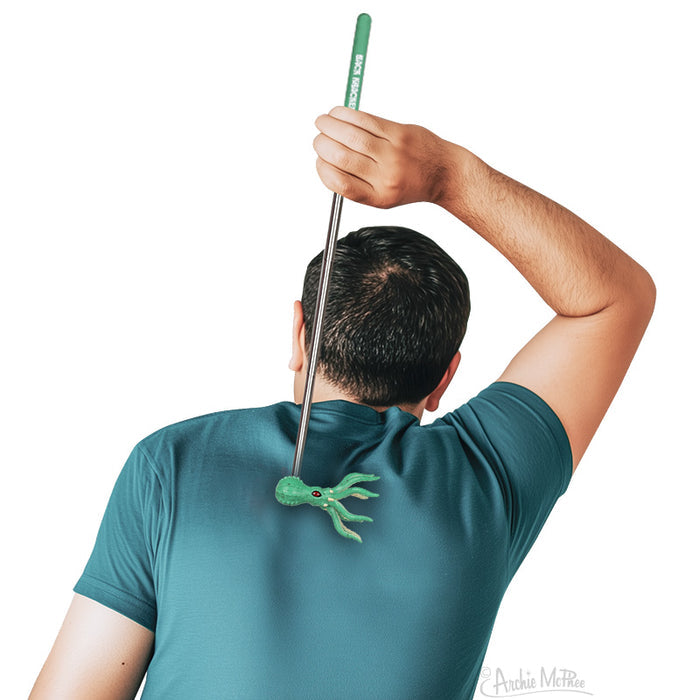 A person uses the Back Kraken green back scratcher while wearing a teal shirt—a fun pirate-themed gift for anyone seeking relief.