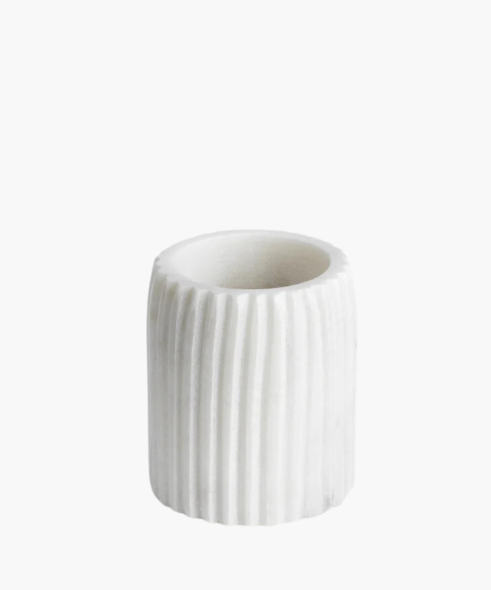 White cylindrical marble tumbler with vertical ridges stands on a white background. The tumbler is simplistic and elegant, exuding a modern, minimalistic vibe. | Wildwood Home Co.