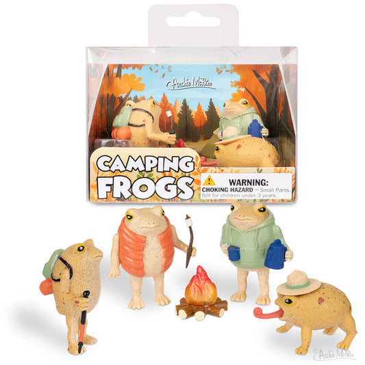 Four vinyl rain frogs in camping gear gather around a campfire, posed before packaging labeled Camping Frogs. This playful set is ideal for fans of outdoor adventures.