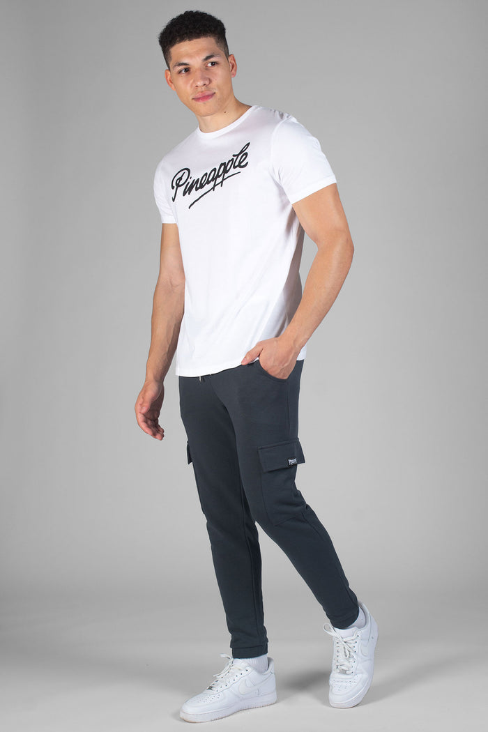 Man wearing charcoal Cargo Joggers with pockets and white t-shirt with black logo