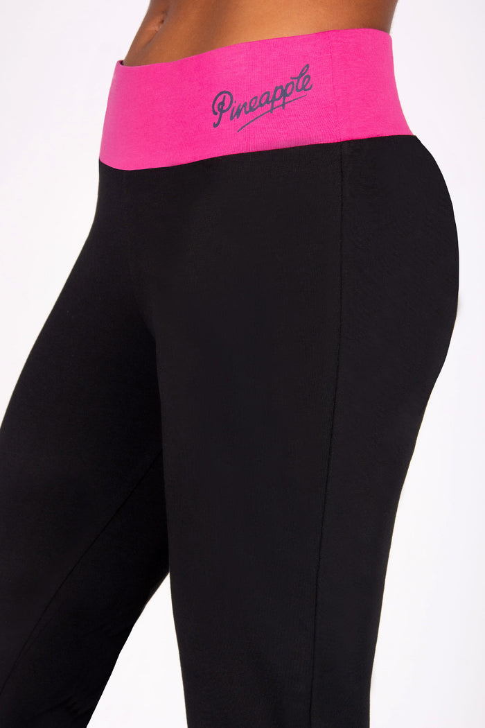 Black leggings with a pink waistband featuring 'Pineapple' branding on a white background