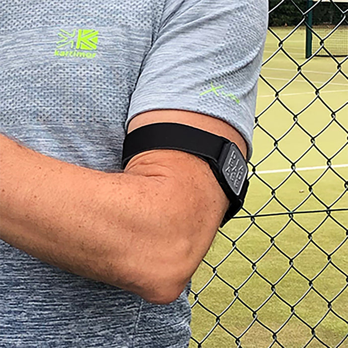 Dexband CGM armband for Dexcom G7 and ONE+ sensors with pewter Diabadass cover and neoprene strap worn on upper arm playing tennis.