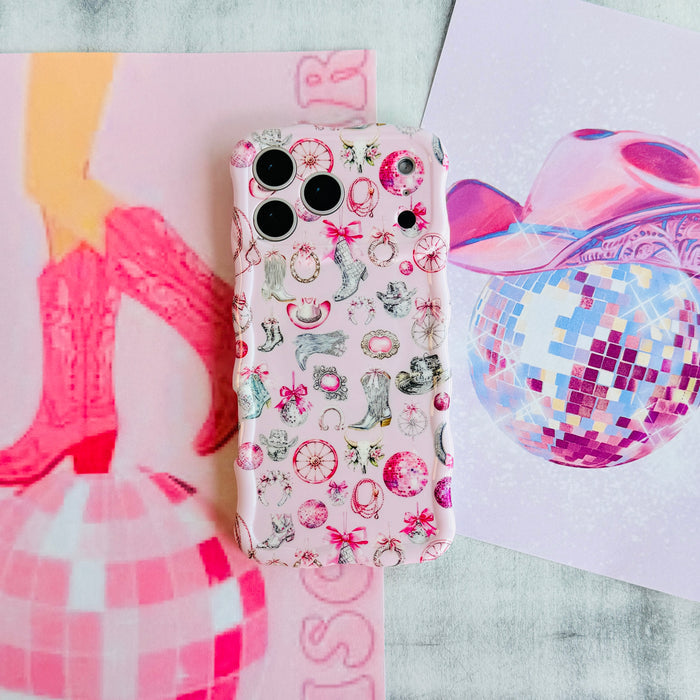 Disco Cowgirl Wavy Luxe MagSafe iPhone case styled with a pink disco ball and cow print paper, showing the pink cowgirl illustration print.