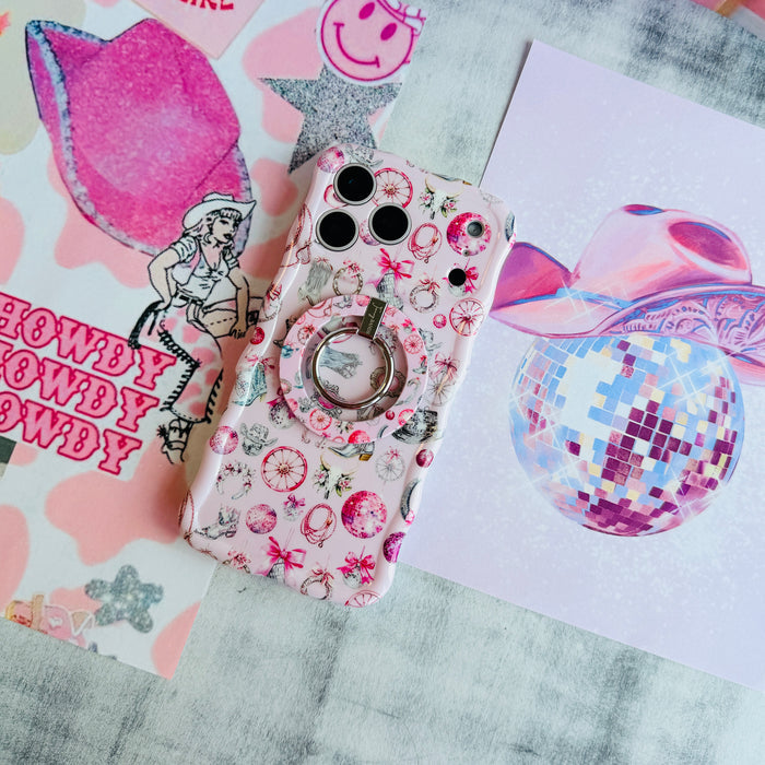 Disco Cowgirl Wavy Luxe iPhone case with the matching MagSafe grip ring attached, styled with a Howdy sign and pink disco ball.