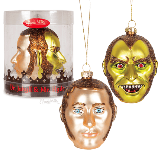 This Dr. Jekyll & Mr. Hyde Ornament set, hand-blown with exquisite detail, showcases a gold, serene figure alongside a green one with fangs, capturing the essence of naughty and nice in Christmas decor, all beautifully presented in clear packaging.