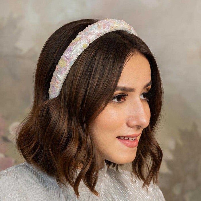 A woman wearing a floral puff hair band in pastel colors.