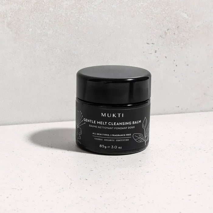 Gentle Melt Cleansing Balm on a textured surface.
