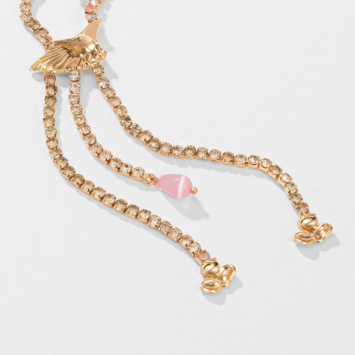 Gold bracelet with heart-shaped charms on a light gray background