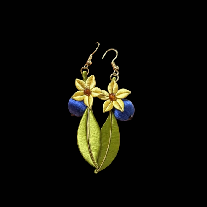 Close-up of blue blueberry and golden flower details on handmade Chanhua earrings