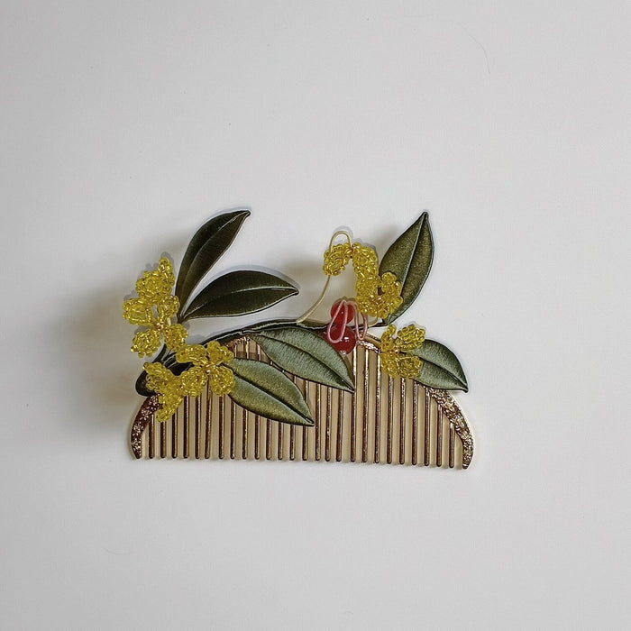 Handcrafted Chanhua thread-wrapped hair comb featuring golden Osmanthus flowers, green leaves, and a small red-accented bunny motif on a gold-tone comb.