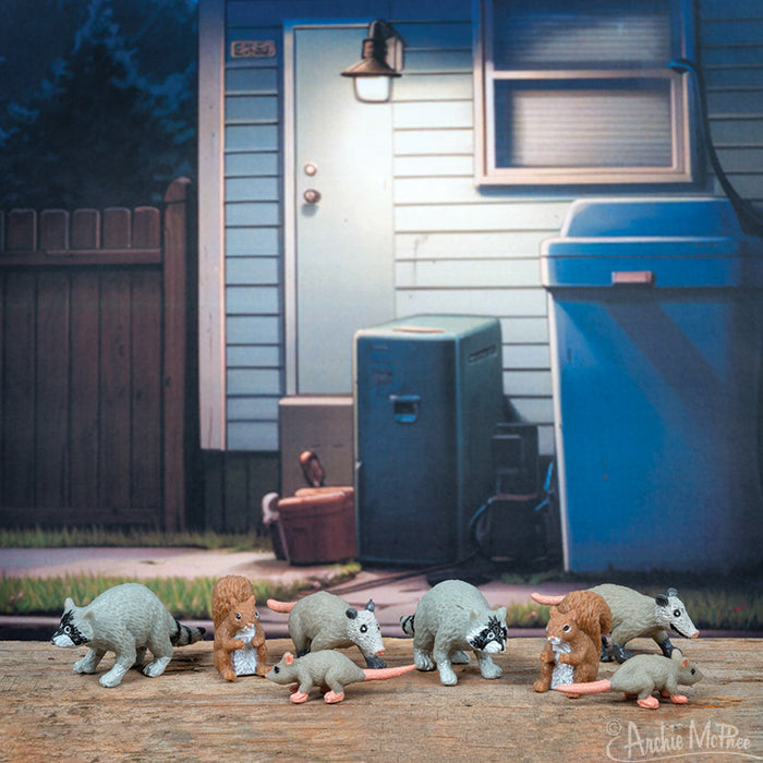 Toy possums, part of the Itty Bitty City Critters line, were grouped together on a table with a house backdrop.