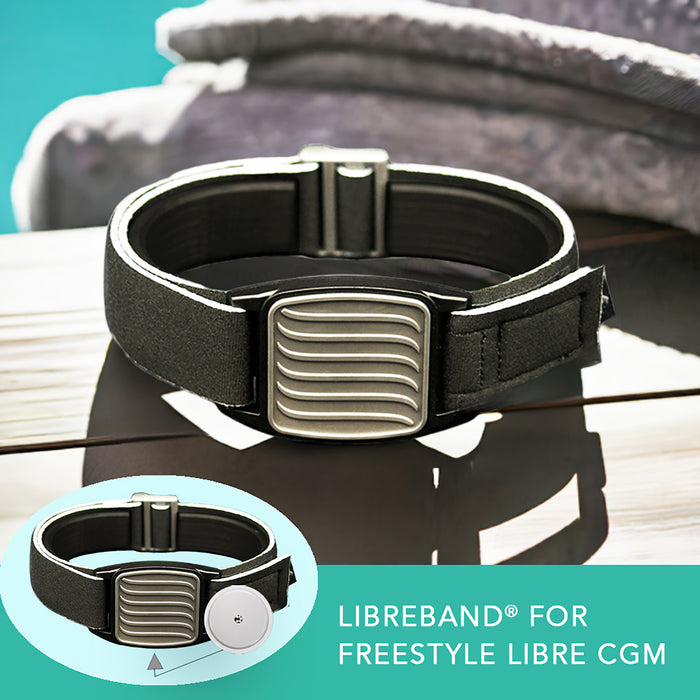 Libreband CGM armband for FreeStyle Libre 2 with pewter wave cover and water-resistant neoprene strap on wooden lounger in swimming pool setting. LML4665, LML2982, LML2555, LML2562.