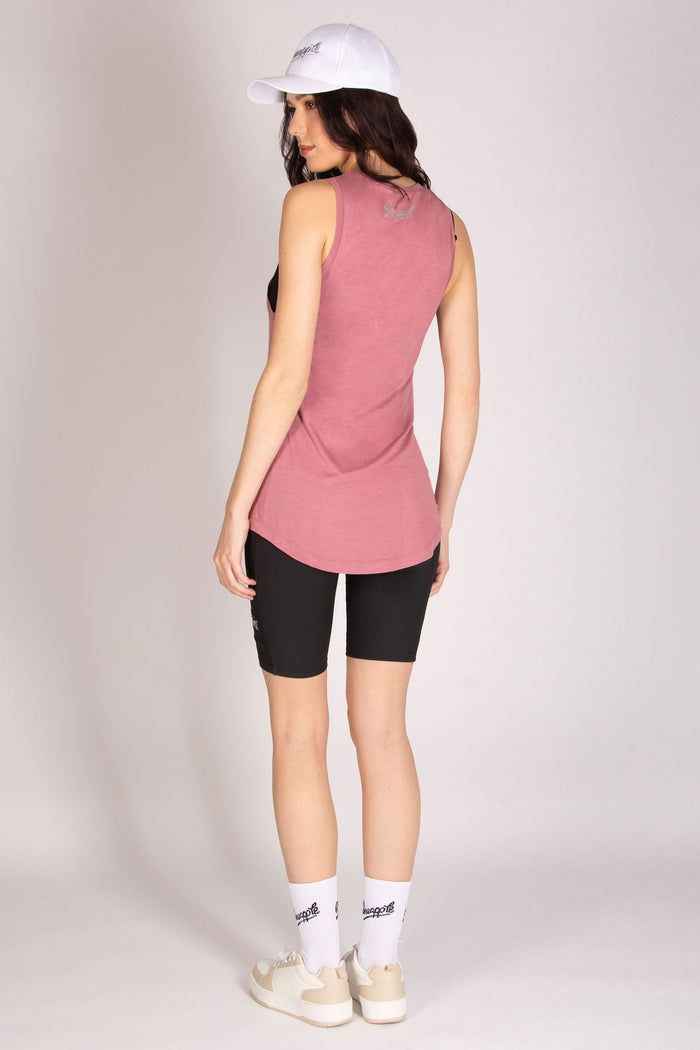 Pink long vest with dipped back and oversized armholes for women paired with white cap and cycling shorts.