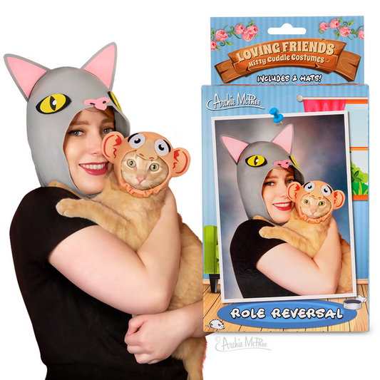 A person and their cat, both wearing matching cat hats, smile for a photo while the Loving Friends Kitty Cuddle Costumes: Role Reversal label is visible on the packaging.