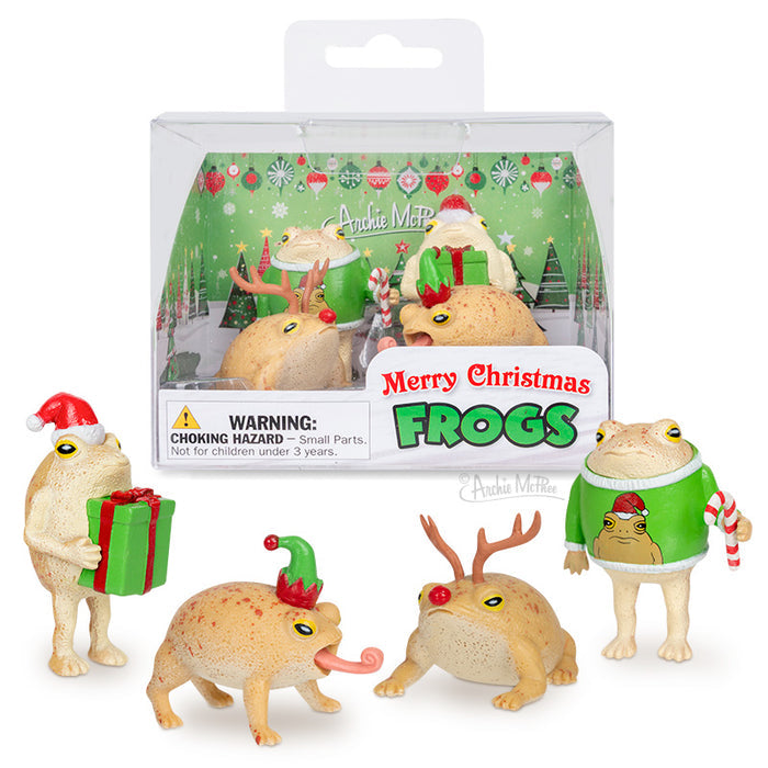 The Merry Christmas Frogs set features four festive vinyl frog figurines in holiday outfits, displayed in front of a cheerful holiday-themed box.