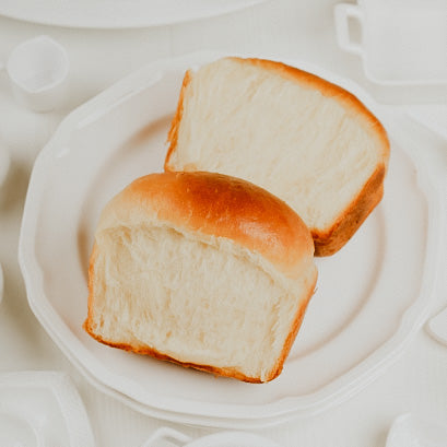 A slice of bread on a white plate, representing the fragrance oil's connection to the scent of bread.
