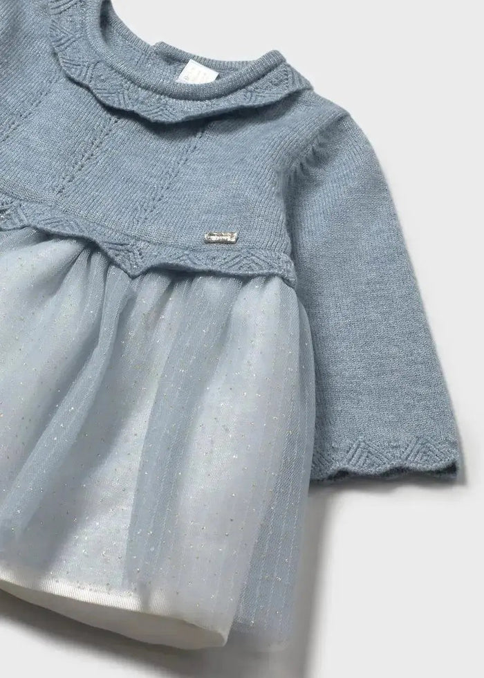 Closeup of Mayoral baby girl dress showing openwork knit texture, ruffled neckline, and tulle detail.