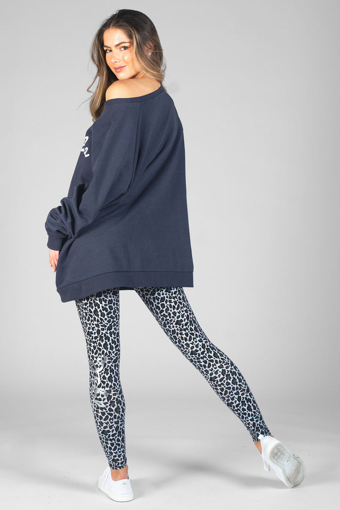 Woman wearing oversized charcoal Monster Monster Top and black Leopard All-over Print Leggings
