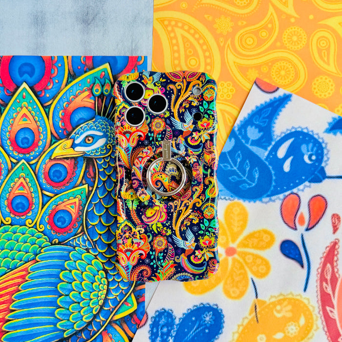 Paisley Birdsong Wavy Luxe iPhone case with the matching MagSafe grip ring attached, styled on folk-art bird and floral paper.