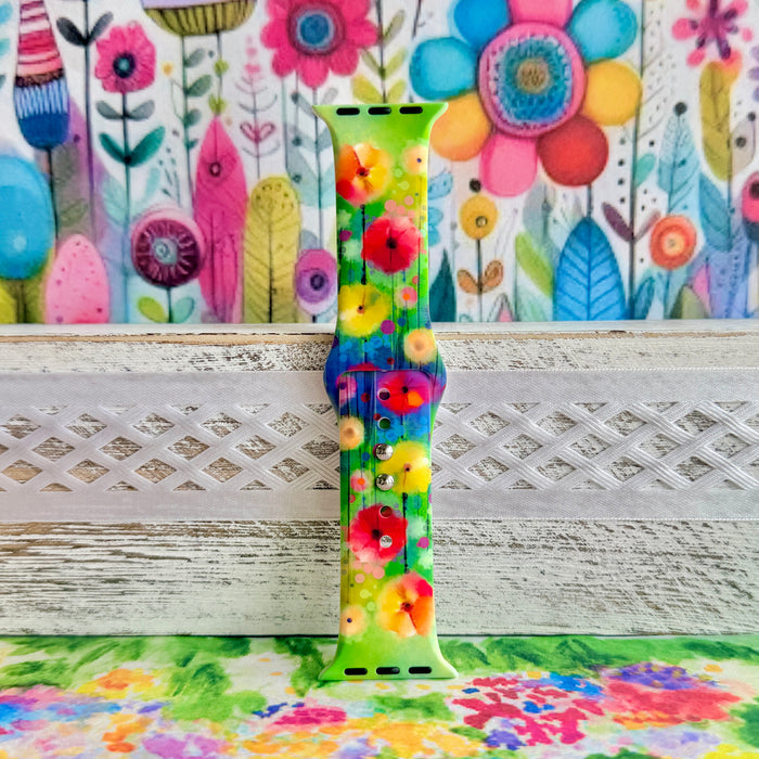Petal Princess Apple Watch band with vibrant watercolor flowers in red, orange, yellow, pink, and blue on green background