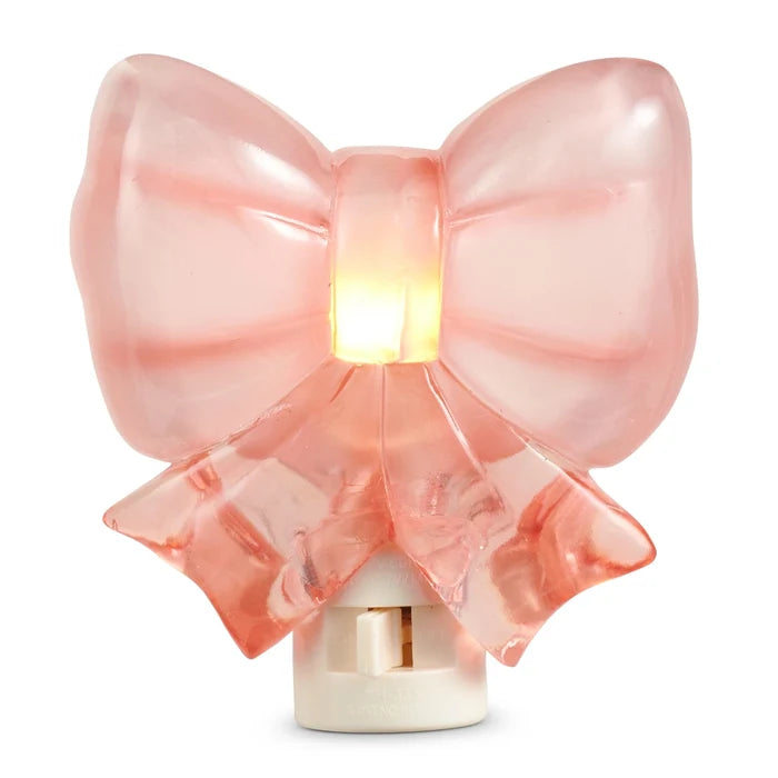 Pink bow-shaped night light on a white background