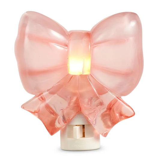 Pink bow-shaped night light on a white background