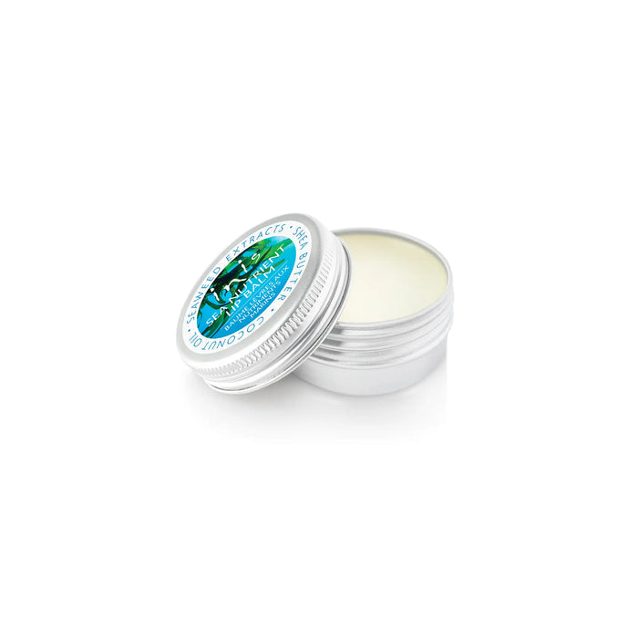 An open silver metal tin of lip balm on a clean white background.