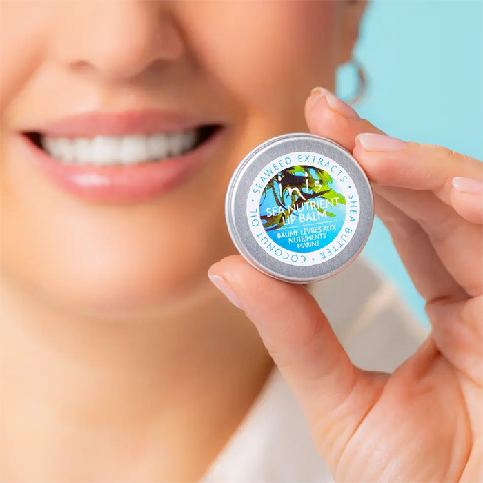 Person holding a lip balm container with a blue background