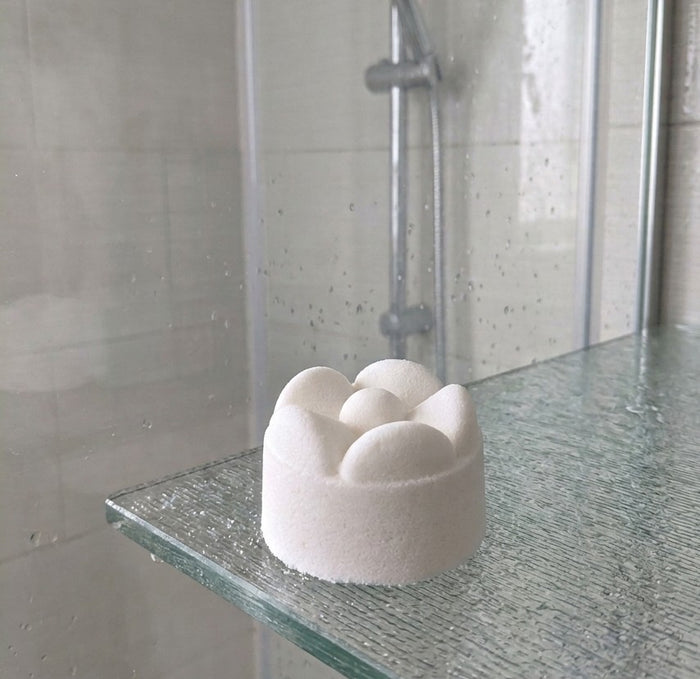 A shower steamer in a shower on a shelf