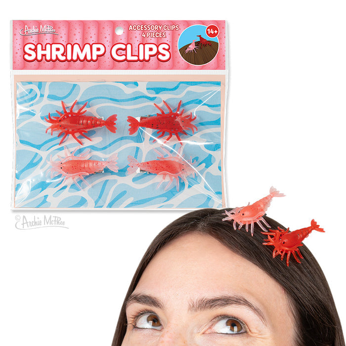 A woman wears Shrimp Clips—shrimp-shaped hair accessories made of soft vinyl; above her, a package shows four novelty Shrimp Clips on a blue background.