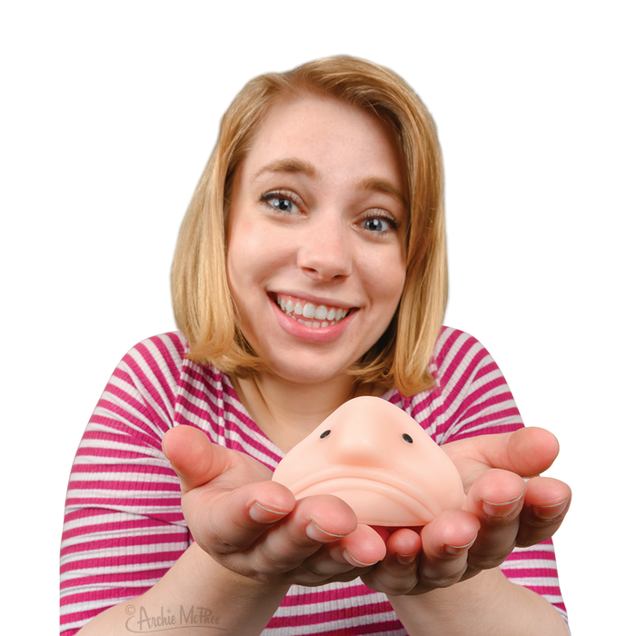 A smiling woman holds Sunny The Happy Blobfish toy in her hands against a white background.