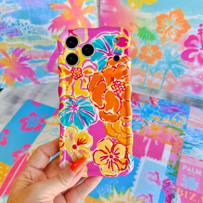 Trendy wavy iPhone case featuring a vibrant pink, orange, and teal hibiscus flower pattern with a high-gloss finish.