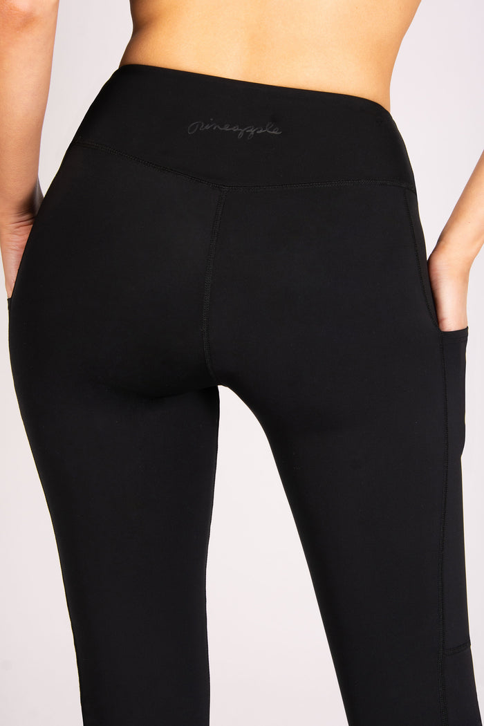 Womne's black super soft gym leggings with minimal branding and convinient side pockets for small gadgets.