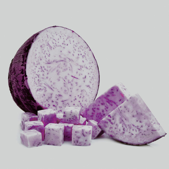 A purple taro root cut into cubes, isolated on a white background.