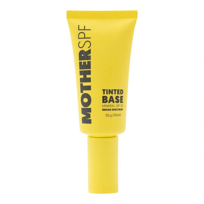 A bright yellow squeeze tube of MOTHER SPF TINTED BASE mineral SPF 50 broad spectrum tinted cream, 50g, on a solid white background.