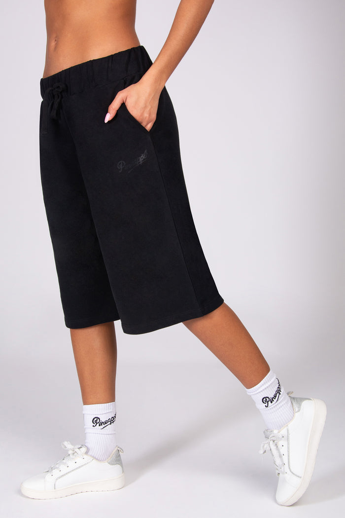 Black super oversized basketball shorts worn by a person on a white background