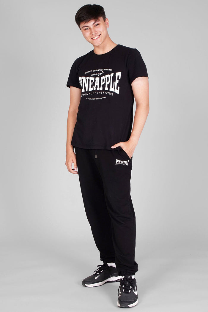 Man wearing Unisex Black T-Shirt and logo black joggers