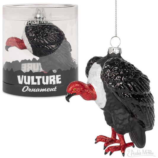 The Vulture Ornament is an exquisite hand-blown glass piece, showcasing a striking red head and feet. It is beautifully presented alongside its cylindrical packaging, making it a unique addition to any Christmas decoration collection.