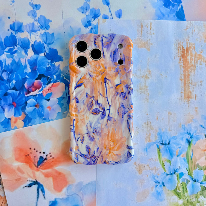 Where Dreams Bloom Wavy Luxe MagSafe iPhone case styled against blue delphinium and watercolor floral artwork.