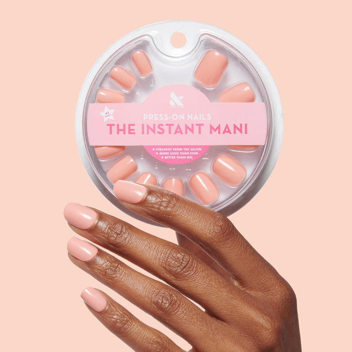 Hand with Wild & Free | Squoval | Extra Short coral squoval shaped press-on nails holding matching press-ons pack