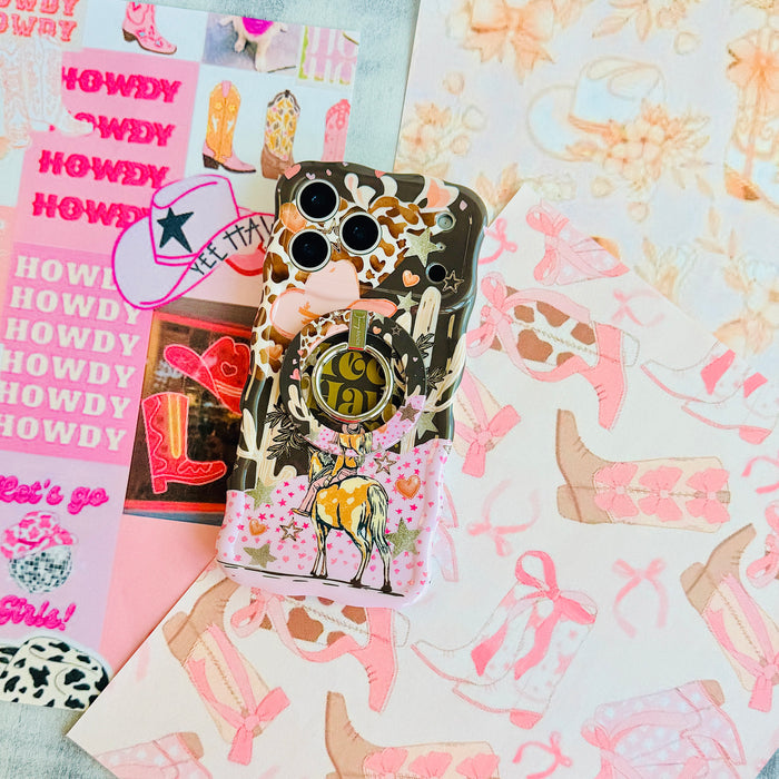 Yee Haw Honey Wavy Luxe iPhone case with the matching MagSafe grip ring attached, styled on pink western boot and bow paper.